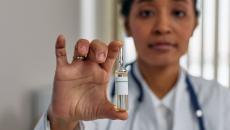 Medical worker holding glass vial