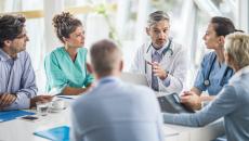 Doctors and payers sit around a table discussing claims data, prior authorizations and more.