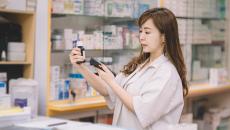 Pharmacist scanning pill bottle