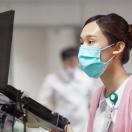 A nurse encoding a patient's record on a laptop